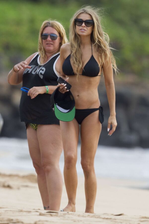 Carmen Electra à la plage se roulant dans le sable