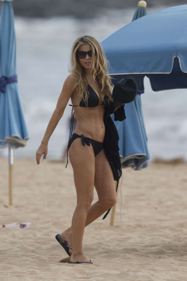 Carmen Electra à la plage se roulant dans le sable