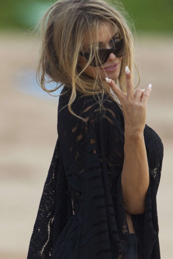 Carmen Electra à la plage se roulant dans le sable