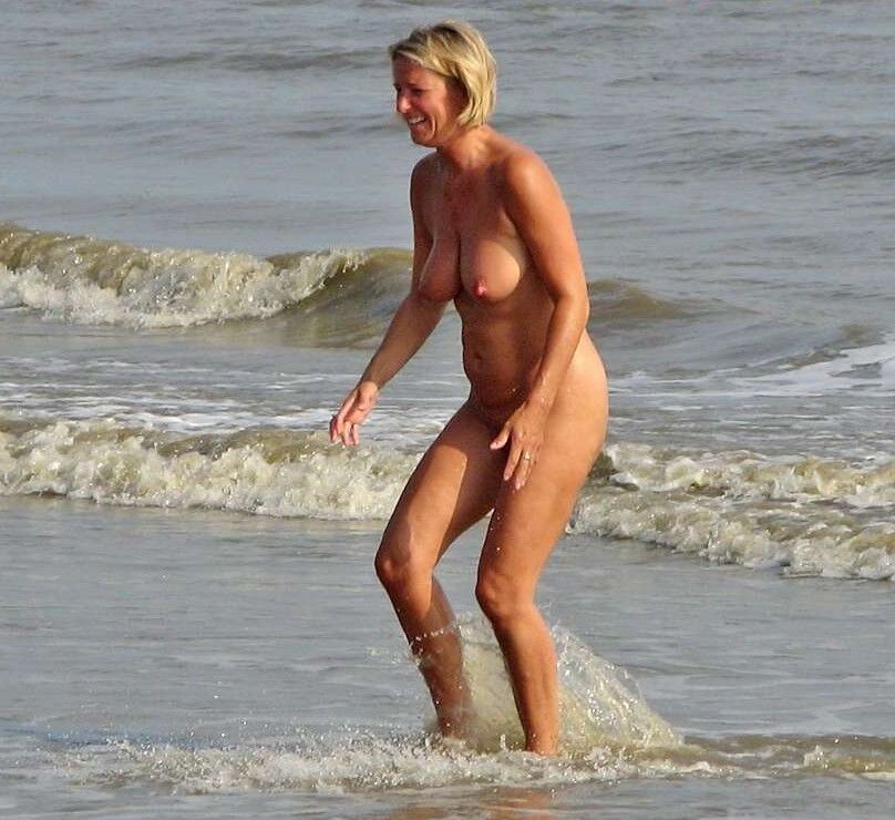 Milf en la playa nudista con un gran par de tetas