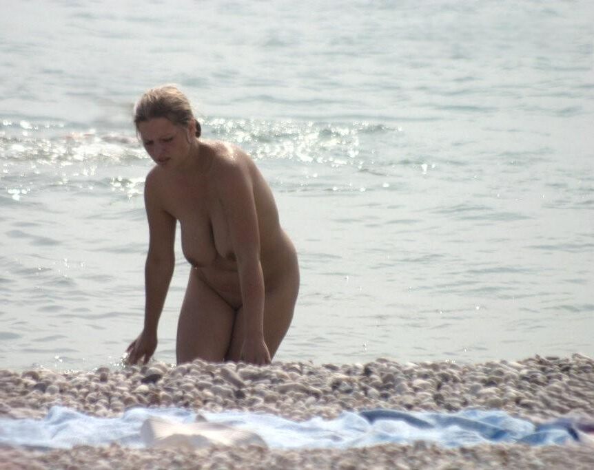 Mamá caliente en la playa nudista con grandes tetas