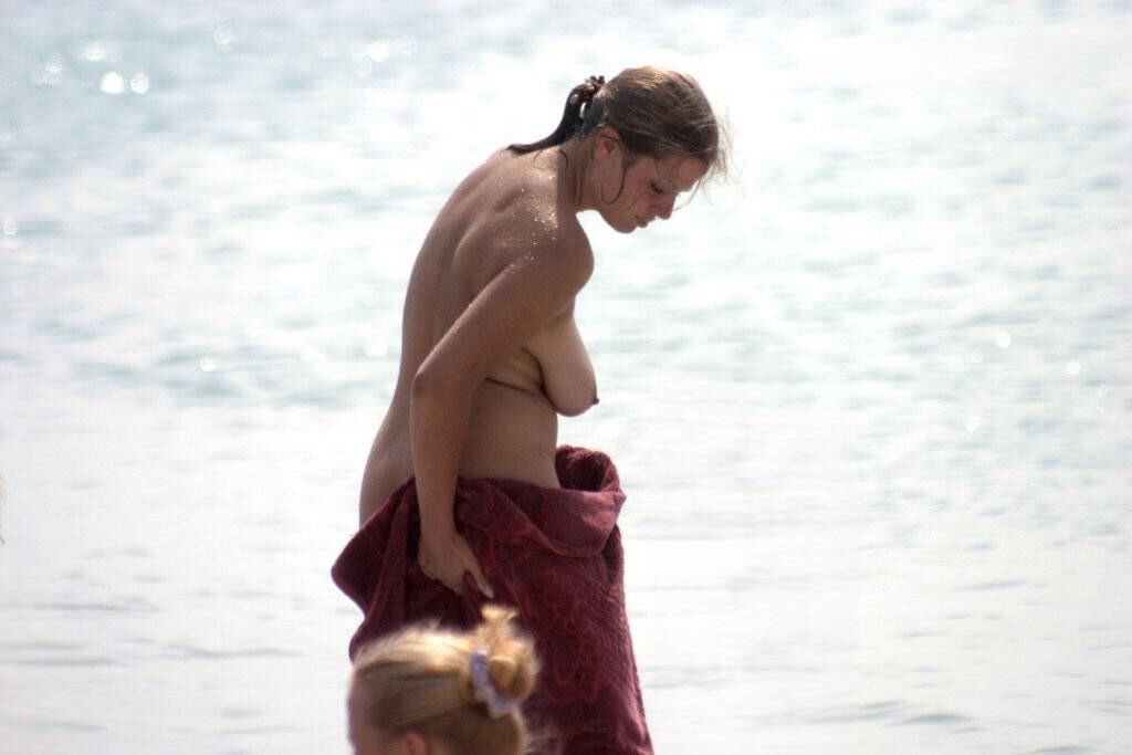 Mamá caliente en la playa nudista con grandes tetas