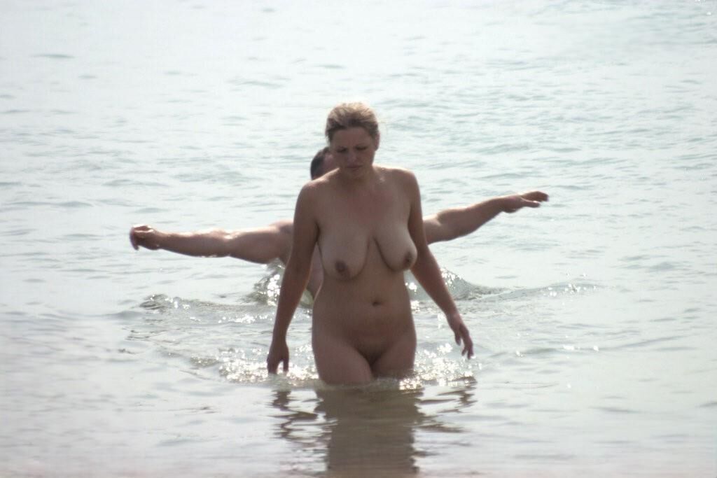 Mamá caliente en la playa nudista con grandes tetas