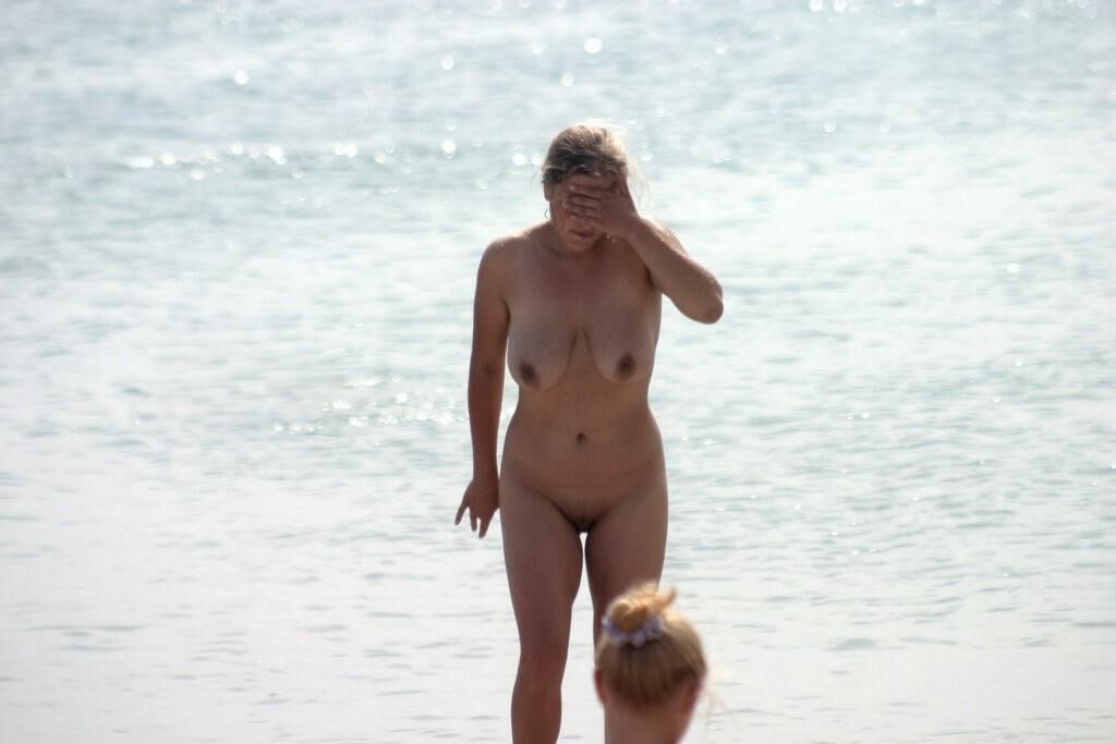 Mamá caliente en la playa nudista con grandes tetas