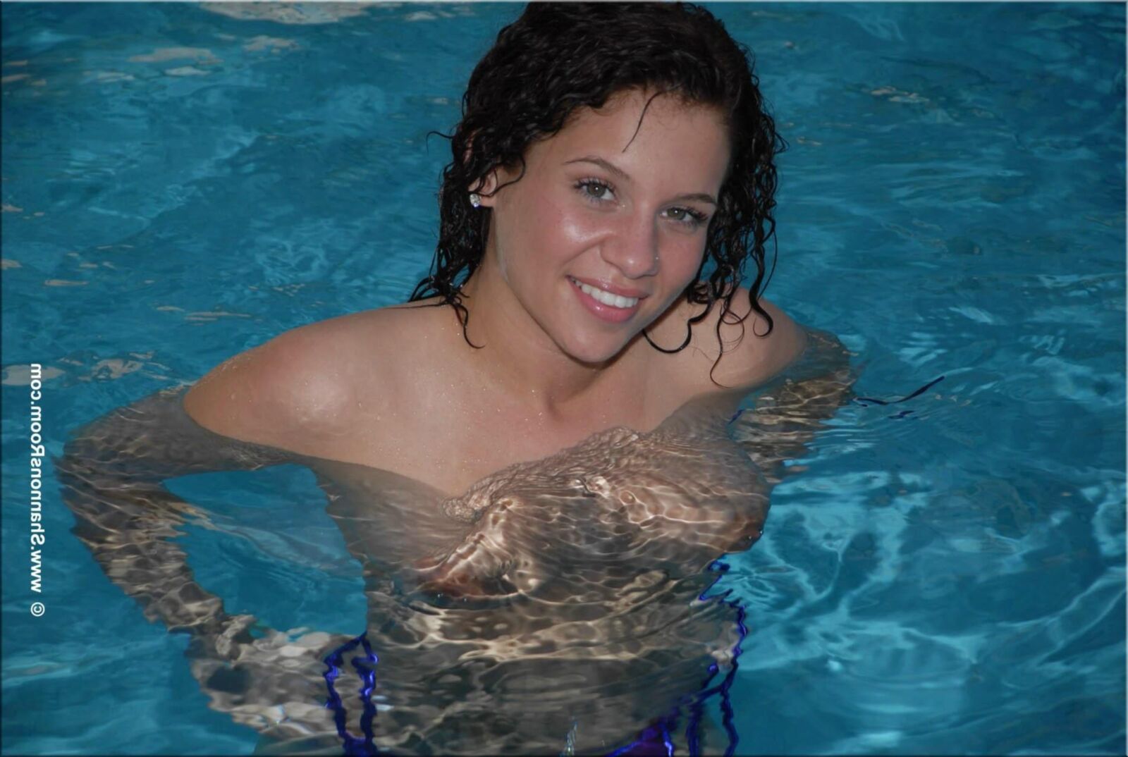Ellie Busty Babe in einem aufschlussreichen lila Bikini wird oben ohne