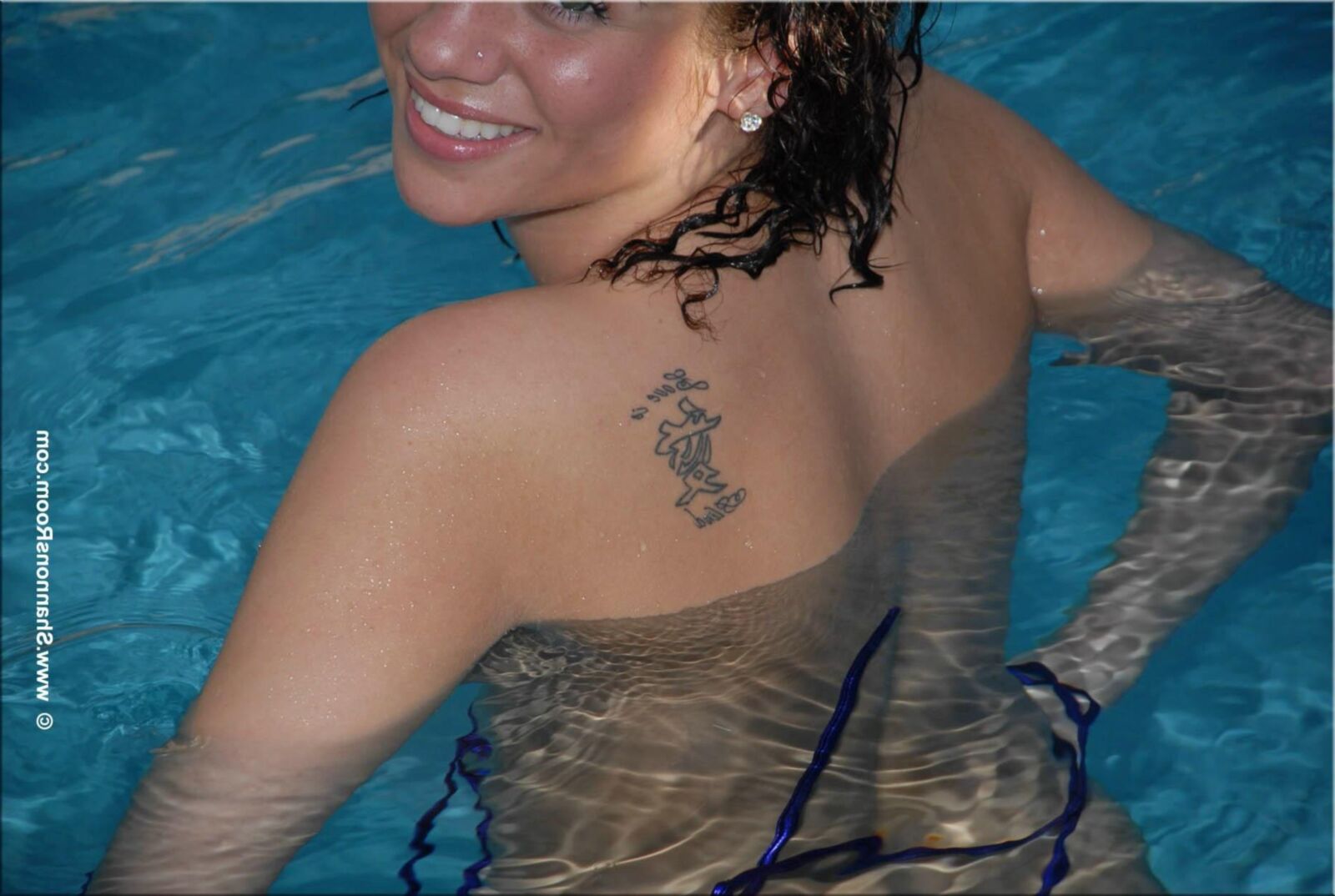 Ellie Busty Babe in einem aufschlussreichen lila Bikini wird oben ohne